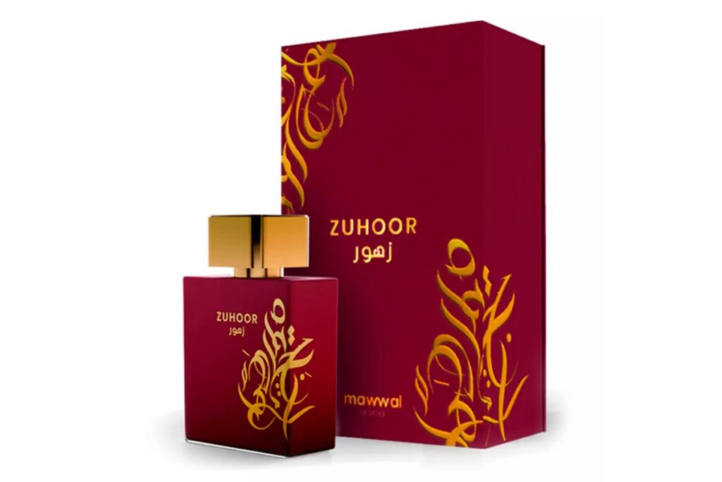 Frasco vermelho do perfume Zuhoor Mawwal com tampa dourada ao lado de uma caixa vermelha decorada com arabescos dourados.