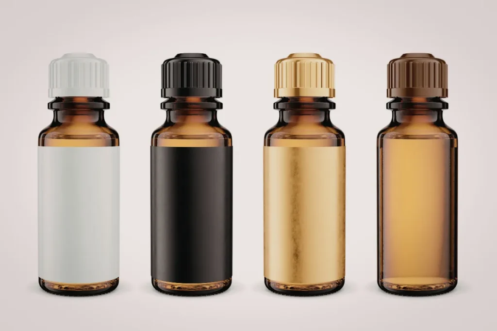 quatro frascos de vidro âmbar com tampas diferentes alinhados sobre fundo claro
