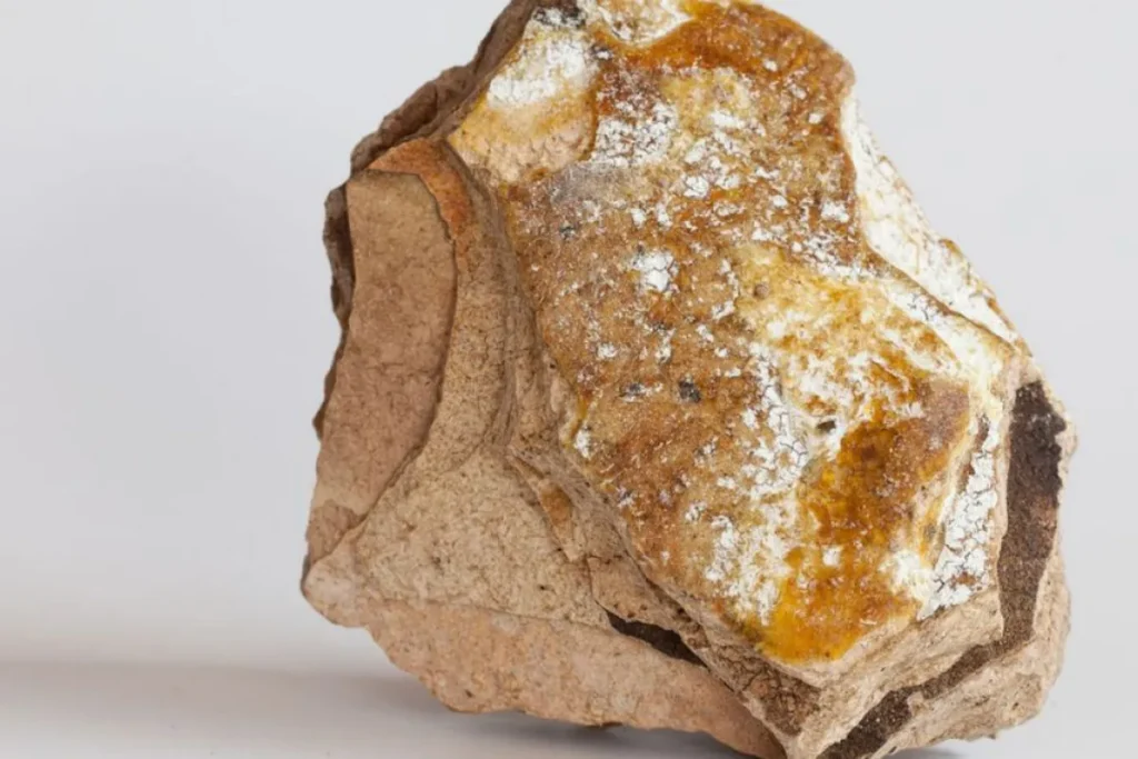 pedaço de âmbar cinza com tons amarelados e textura mineral