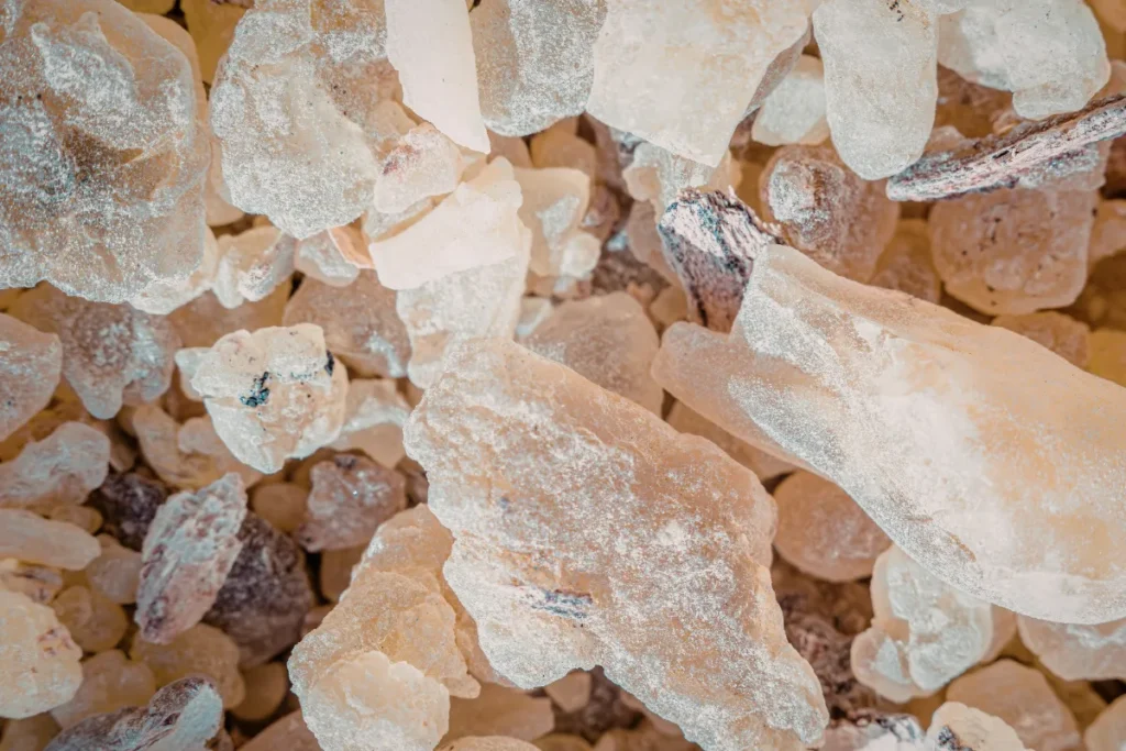 Fragmentos de resina de benjoim em diferentes tamanhos e tons claros utilizados na perfumaria.