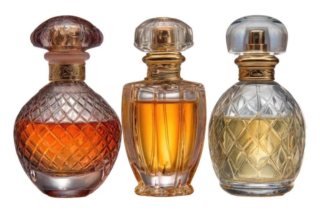 três frascos clássicos de perfume com vidro texturizado e líquidos em tons dourados