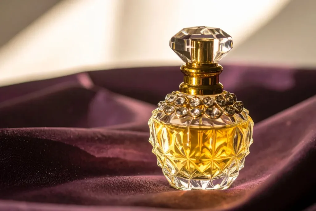 frasco de perfume com design luxuoso em vidro lapidado dourado sobre tecido de veludo
