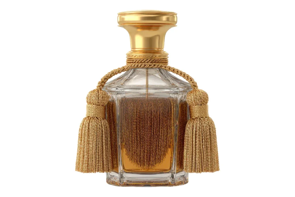 Frasco de perfume em vidro transparente com tampa dourada e detalhes decorativos de cordão com pingentes.