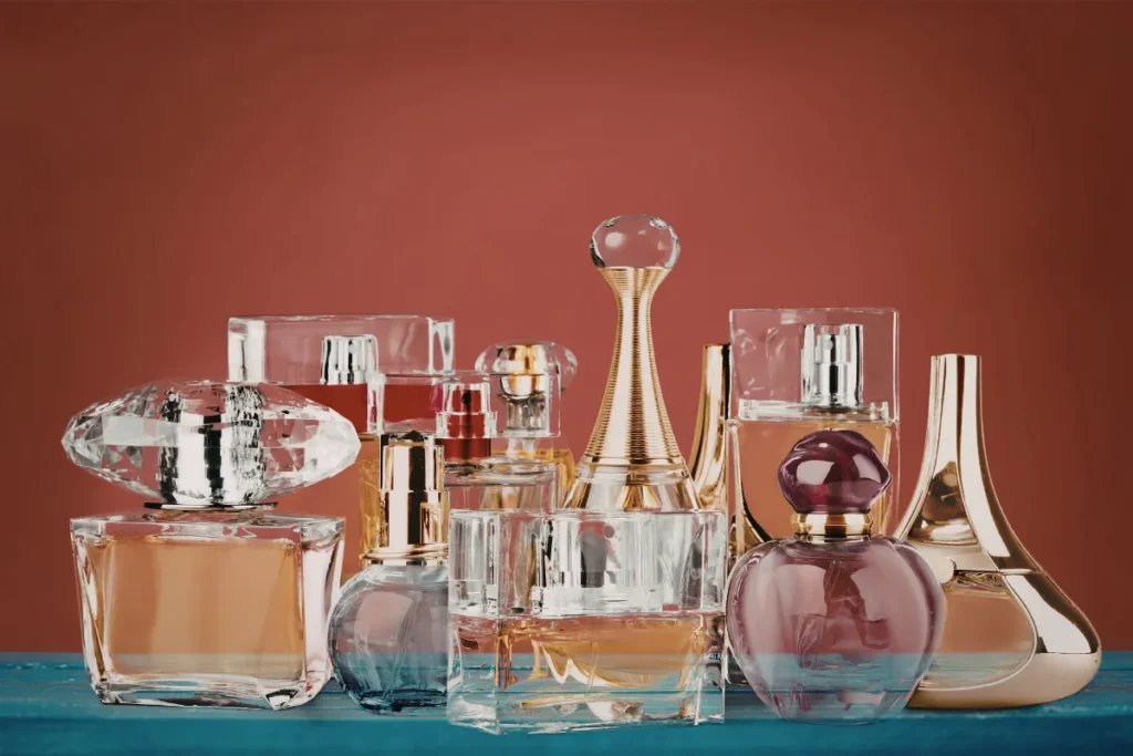 Vários frascos de perfumes femininos com designs diferentes organizados lado a lado sobre uma superfície.